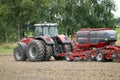 Farmer plowing the field Cultivating tractor in the field Red farm tractor with a plow in a farm field Tractor and Plow. Lithuania