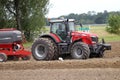 Farmer plowing the field Cultivating tractor in the field Red farm tractor with a plow in a farm field Tractor and Plow. Lithuania