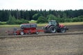 Farmer plowing the field Cultivating tractor in the field Red farm tractor with a plow in a farm field Tractor and Plow. Lithuania