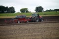 Farmer plowing the field Cultivating tractor in the field Red farm tractor with a plow in a farm field Tractor and Plow. Lithuania