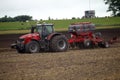 Farmer plowing the field Cultivating tractor in the field Red farm tractor with a plow in a farm field Tractor and Plow. Lithuania