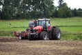 Farmer plowing the field Cultivating tractor in the field Red farm tractor with a plow in a farm field Tractor and Plow. Lithuania