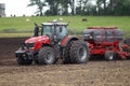 Farmer plowing the field Cultivating tractor in the field Red farm tractor with a plow in a farm field Tractor and Plow. Lithuania