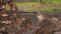 Farmer plowing rice field for planting in organic farm agriculuture in Thailand, farmer in field for working with tractor,