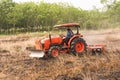 Farmer plowing stubble field with orange tractor Royalty Free Stock Photo