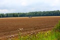 Farmer plowing stubble field with red tractor Royalty Free Stock Photo