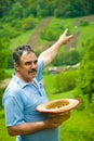 Farmer pointing to his plowing land on hill Royalty Free Stock Photo