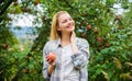 Farmer pretty blonde with appetite red apple. Harvesting season concept. Woman hold apple garden background. Farm Royalty Free Stock Photo