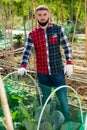 Farmer pulls protective net on greenhouse