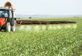 Farmer in red tractor spraying soybean field Royalty Free Stock Photo