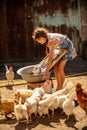 Farmer`s daughter is washing his father`s shirt in courtyard, surrounded by chickens. A cute girl is happy, helping family Royalty Free Stock Photo