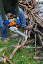 Farmer sawing a log with a chainsaw