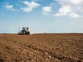 Farmer seeding, sowing crops at field.