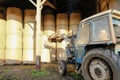 Farmer seen in his tractor loading bales in a straw shed. Royalty Free Stock Photo