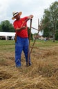 Farmer sharpening his scythe