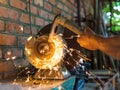 Farmer sharpens a hack on electric grindstone