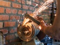 Farmer sharpens a hoe on electric grindstone