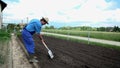 Farmer shovels the soil and turns it over shot in slow motion