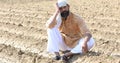 Farmer is sitting in a agricultural field during the long drought