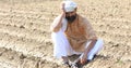 Farmer is sitting in a agricultural field during the long drought