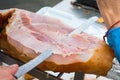 Farmer Slicing with Long Knife Smoked Baked Pork Ham from Leg at Market. Close up of Meat Texture. Vibrant Colors. Organic Produce