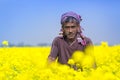 A farmer is smiling in full blooming mustard field at Sirajdhikha, Munshigonj, Dhaka, Bangladesh.