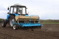 A farmer with a sowing tractor - sowing crops on an agricultural field. Plants, wheat.