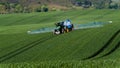 A farmer spraying with a John Deere tractor