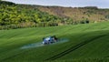 A farmer spraying on the spring wheat field