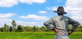 Farmer standing back at rice field, farmers man looking sky horizon at rice plantation, labor rear back view, rural scenery