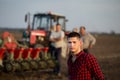 Farmer standing in field with tractor