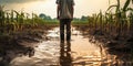 Farmer standing in a flooded cornfield, reflecting on climate change\'s impact on agriculture Royalty Free Stock Photo