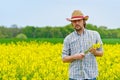 Farmer Standing in Oilseed Rapseed Cultivated Agricultural Field Royalty Free Stock Photo