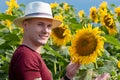 Farmer standing in sunflower field examining the crop. Royalty Free Stock Photo