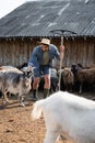 farmer in straw hat holding rakes