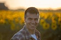 Farmer in sunflower field at sunset