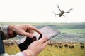 Farmer with tablet computer and drone inspects cows in the pasture. Royalty Free Stock Photo