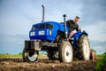 A farmer on a tractor cleans the field after harvest. Preparation of land for future planting new crop. Intensive land use.