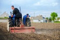 A farmer on a tractor cleans the field after harvest. Running a small agribusiness. Farm work. Softening soil before planting