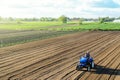 Farmer on a tractor cultivates a farm field. Grinding and loosening soil, removing plants and roots from past harvest. Field