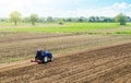 A farmer on a tractor cultivates a farm field. Field preparation for new crop planting. Cultivation equipment. Grinding and