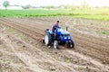 A farmer on a tractor cultivates a farm field. Soil milling, crumbling and mixing. Agroindustry, farming. Preparatory work for a