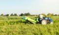 A farmer on a tractor digs potatoes in the farm field. Countryside. Food production. Harvesting potatoes in autumn. Extract root