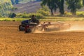 Farmer tractor with disc harrow system working on a stubble field