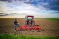 Farmer with tractor preparing field for sowing. Royalty Free Stock Photo