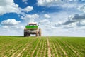 Farmer in tractor fertilizing wheat field at spring with npk. Royalty Free Stock Photo