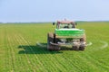 Farmer in tractor fertilizing wheat field at spring with npk. Royalty Free Stock Photo