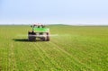 Farmer in tractor fertilizing wheat field at spring with npk. Royalty Free Stock Photo