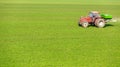 Farmer in tractor fertilizing wheat field at spring with npk. Royalty Free Stock Photo