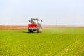 Farmer in tractor fertilizing wheat field at spring with npk Royalty Free Stock Photo